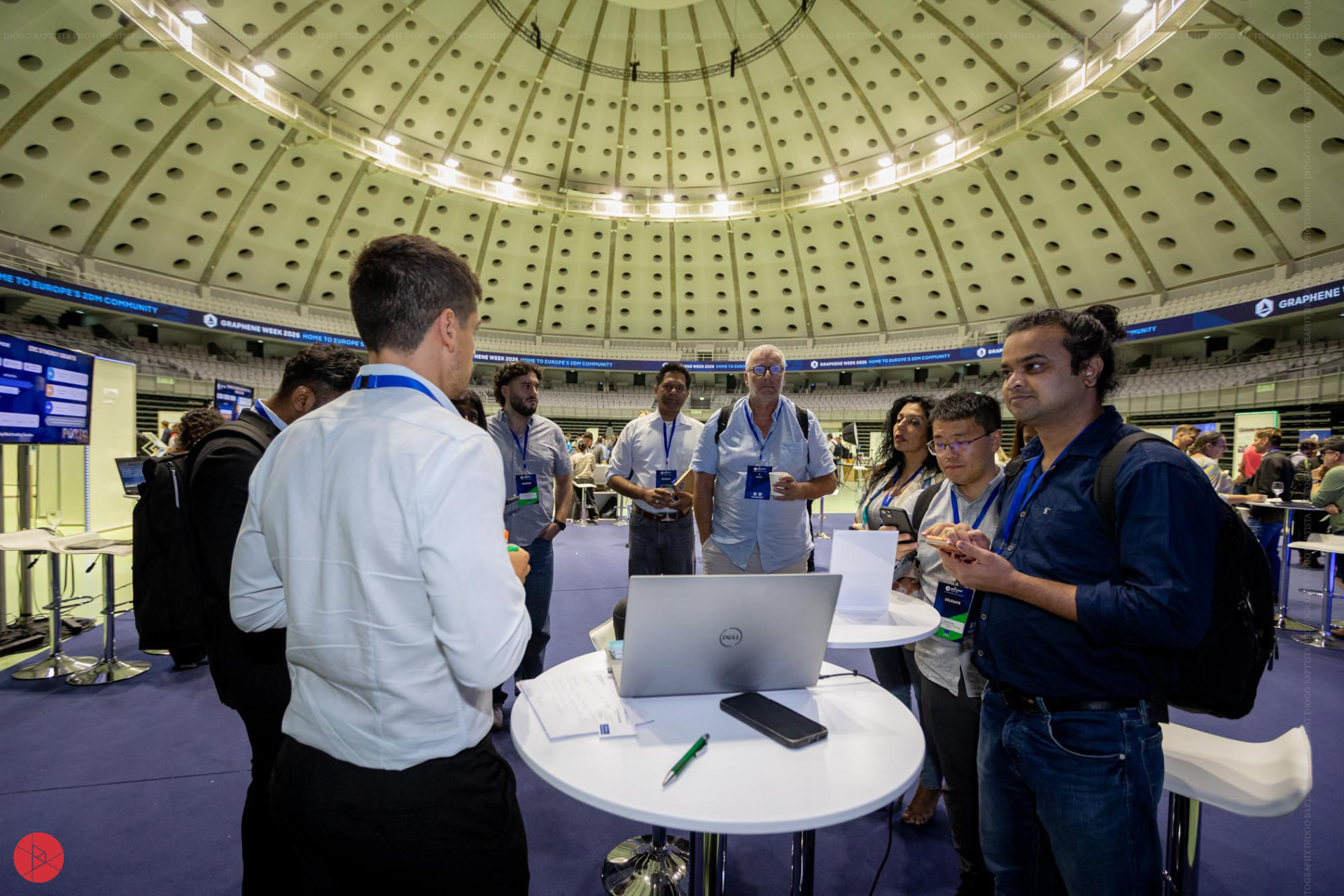Researchers and delegates exchanging ideas beneath the arena dome